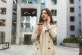 Young business lady drinking hot coffee walking down the street near office center with cup of coffee looking busy, multitasking Royalty Free Stock Photo