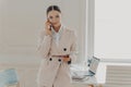 Young business lady talking on phone and discussing business ideas Royalty Free Stock Photo