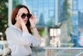 Business lady wears sunglasses on the background of business center, success and career