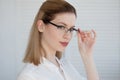 Young business lady in white shirt and glasses. Attractive young woman smiling Royalty Free Stock Photo