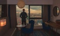 Young business man on the background of the panoramic windows with the view on the city from the hotel room at sunset time Royalty Free Stock Photo