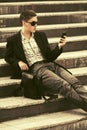 Young business man with cell phone sitting on steps Royalty Free Stock Photo