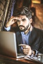 Young business man checking online his bank account. Not happy. Royalty Free Stock Photo