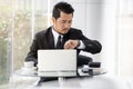 Business man checking time on smart watch while using laptop Royalty Free Stock Photo