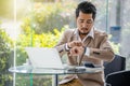 Business man checking time on smart watch while using laptop Royalty Free Stock Photo