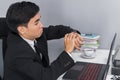 Business man checking time on watch while using laptop Royalty Free Stock Photo