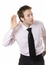 Young business man cupping hand behind ear on whit Royalty Free Stock Photo