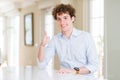 Young business man with curly read head doing happy thumbs up gesture with hand Royalty Free Stock Photo