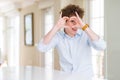 Young business man with curly read head Doing heart shape with hand and fingers smiling looking through sign Royalty Free Stock Photo