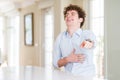 Young business man with curly read head laughing at you, pointing finger to the camera with hand over body, shame expression Royalty Free Stock Photo