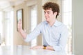 Young business man with curly read head Looking proud, smiling doing thumbs up gesture to the side Royalty Free Stock Photo