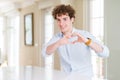 Young business man with curly read head smiling in love doing heart symbol shape with hands Royalty Free Stock Photo