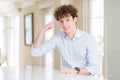 Young business man with curly read head Smiling pointing to head with one finger, great idea or thought, good memory Royalty Free Stock Photo