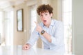 Young business man with curly read head Surprised pointing with finger to the side, open mouth amazed expression Royalty Free Stock Photo