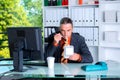 Young business man at his desk is eating Royalty Free Stock Photo