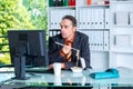 Young business man at his desk is eating Royalty Free Stock Photo