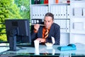 Young business man at his desk is eating Royalty Free Stock Photo