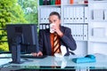 Young business man at his desk is eating and drinking Royalty Free Stock Photo