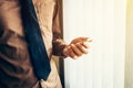 Young business man holding smartphone in the office with sunlight. Vintage toned filter. Royalty Free Stock Photo