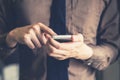 Young business man holding and using smartphone in the office wi Royalty Free Stock Photo