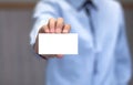 Young business man holding white business card on modern office blur background Royalty Free Stock Photo