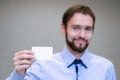 Young business man holding white business card on modern office blur background Royalty Free Stock Photo