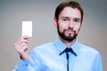 Young business man holding white business card on modern office blur background Royalty Free Stock Photo