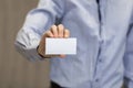 Young business man holding white business card on modern office blur background Royalty Free Stock Photo