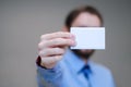 Young business man holding white business card on modern office blur background Royalty Free Stock Photo