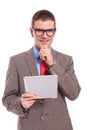 Young business man holds tablet and smiles with hand on chin Royalty Free Stock Photo