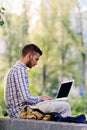 Young business man with laptop working in the park near office building Royalty Free Stock Photo