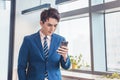 Young  business man looking at his smartphone in office Royalty Free Stock Photo