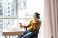 Young business man looking at pc computer screen and holding coffee cup in office Royalty Free Stock Photo