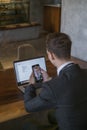 Young business man makes video call on mobile phone and working with laptop Royalty Free Stock Photo