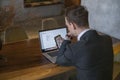 Young business man makes video call on mobile phone and working with laptop Royalty Free Stock Photo