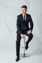 Young business man in modern suit sitting on chair