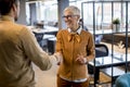 Young business man and senior business woman shaking hands in the office Royalty Free Stock Photo