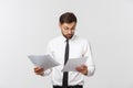 Young business man serious writing on clipboard, Handsome businessman wear elegant suit and tie isolated over white Royalty Free Stock Photo