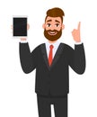 Young business man showing/holding blank screen of new digital tablet computer and pointing index finger up. Modern technology. Royalty Free Stock Photo