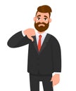 Young business man showing thumbs down sign, dislike, looks with negative expression and disapproval.