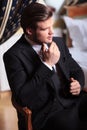 Young business man sits on vintage chair Royalty Free Stock Photo