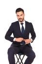 Young business man sitting on chair and buttoning his coat Royalty Free Stock Photo