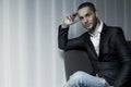 Young business man sitting on a chair and looking at the camera Royalty Free Stock Photo