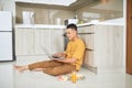 Young business man is smiling, eating breakfast and working on laptop in bright kitchen Royalty Free Stock Photo