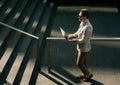 Young business man spending time outdoors at the city, using laptop computer on stairs Royalty Free Stock Photo