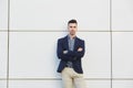 Young business man standing against white wall with arms crossed Royalty Free Stock Photo