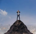 Young business man standing on top of mountain and spying by bin Royalty Free Stock Photo