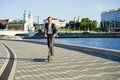 Young business man in a suit riding an electric scooter on a business meeting. Royalty Free Stock Photo