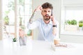 Young business man talking on smartphone annoyed and frustrated shouting with anger, crazy and yelling with raised hand, anger Royalty Free Stock Photo