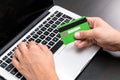 Young business man typing in credit card info on a computer keyboard. Credit card visible in hand. Close up, business office work Royalty Free Stock Photo